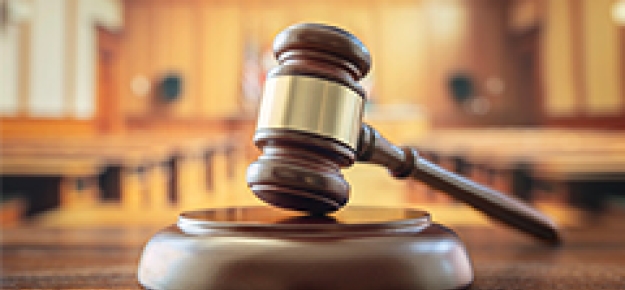 image of a gavel on a courtroom desk